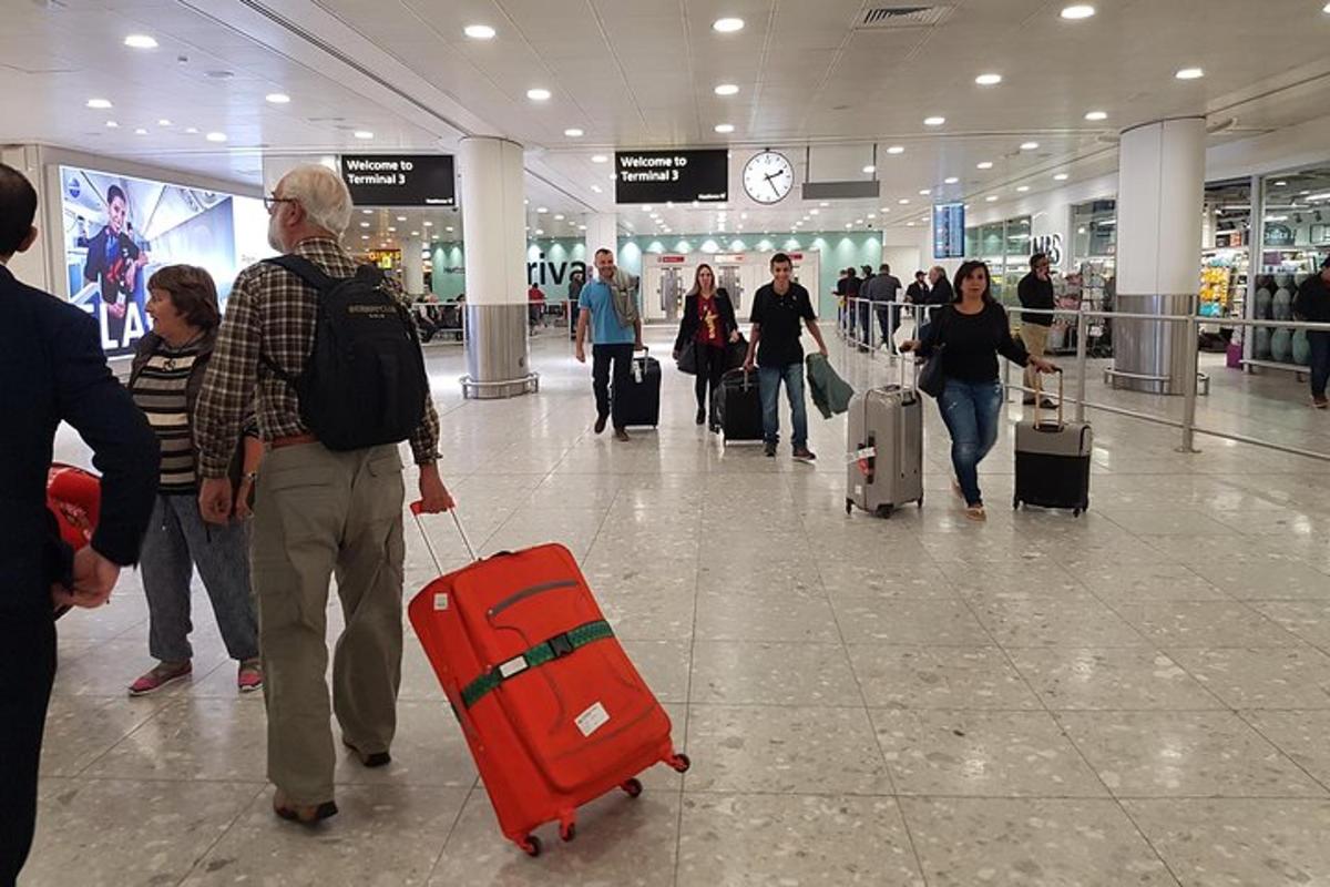 un grup de persones caminant per un aeroport amb equipatge