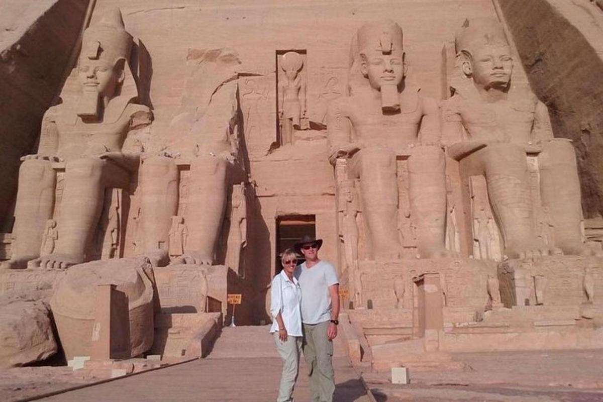 vīrietis un sieviete stāv statujas priekšā