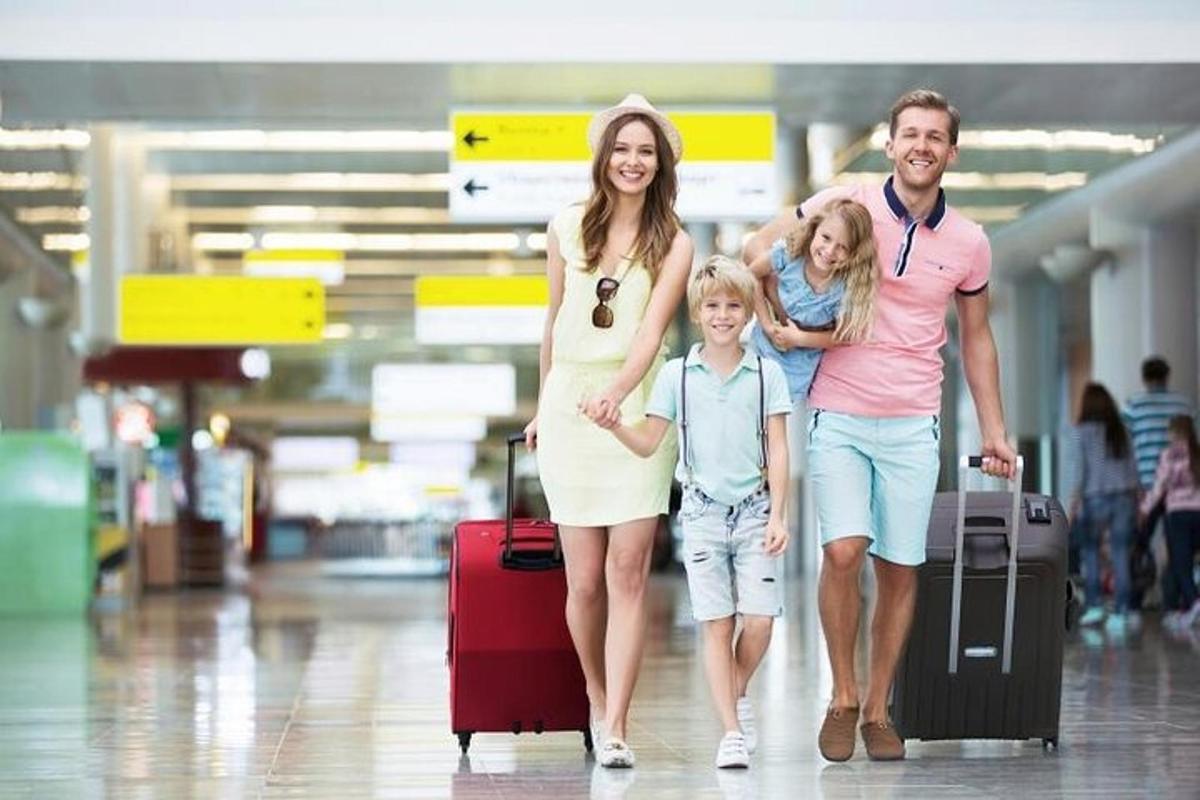 uma família caminhando por um aeroporto com sua bagagem