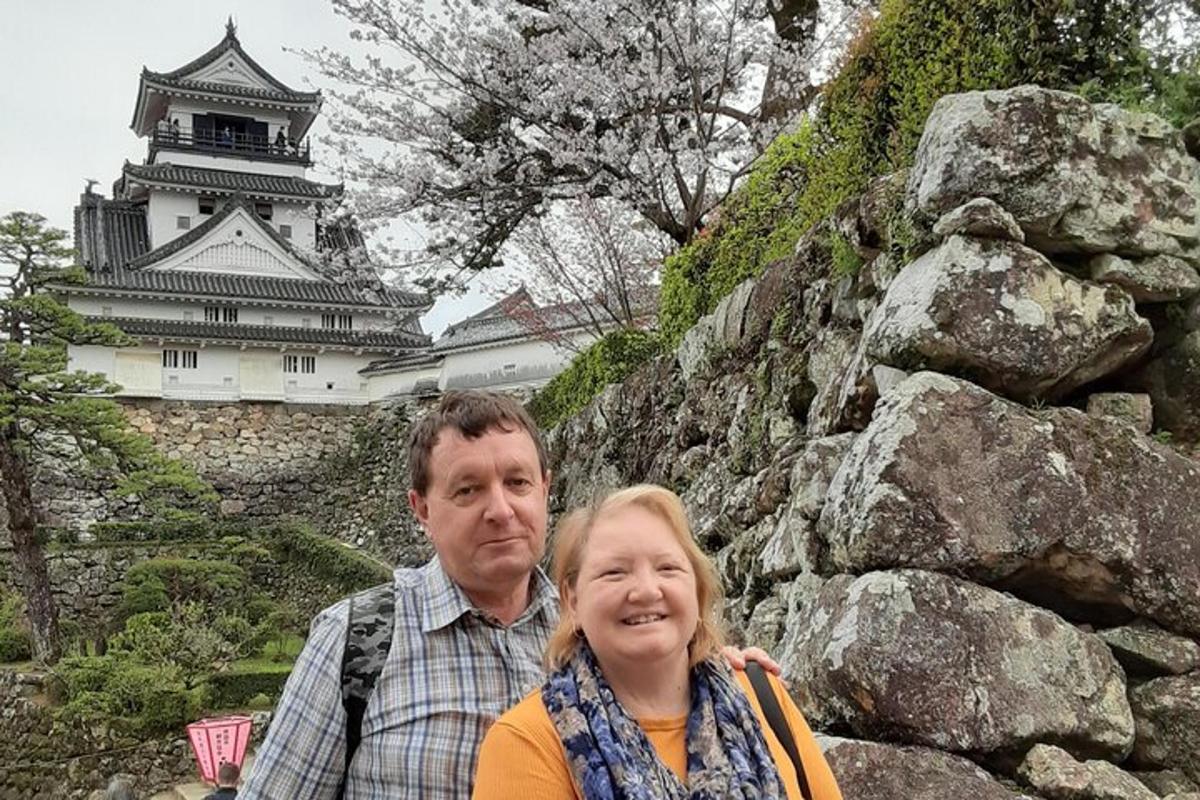 a man and a woman standing in front of a castle
