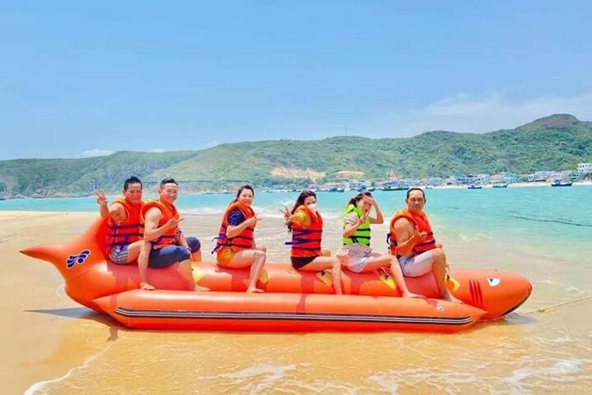 skupina lidí jedoucích na raftu na pláži
