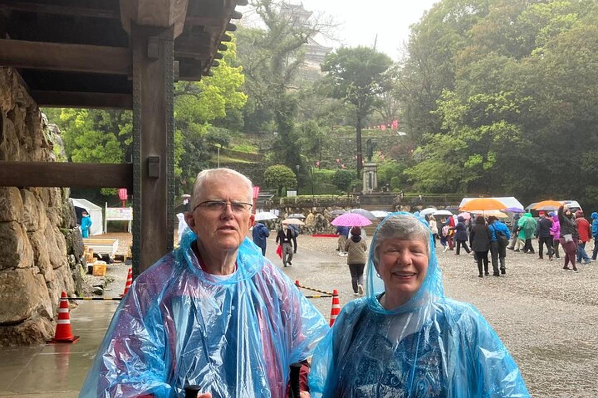 a couple of people wearing raincoats walking in the rain