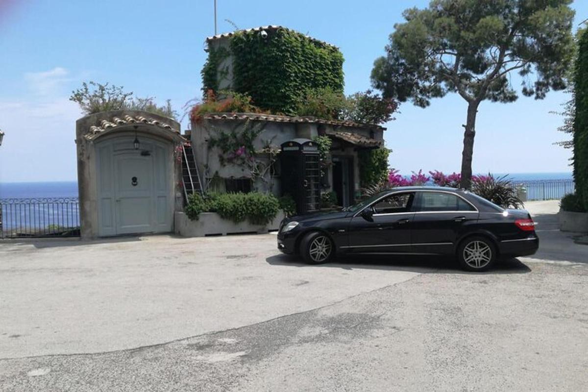 bir evin önünde park edilmiş siyah bir araba