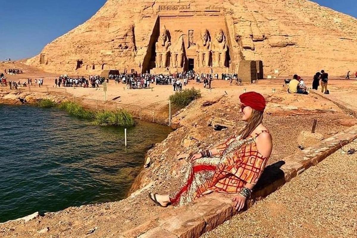 žena sedící na zdi před pyramidou