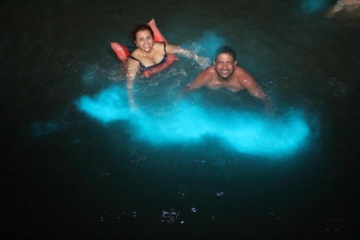 duas pessoas estão deitadas na água à noite