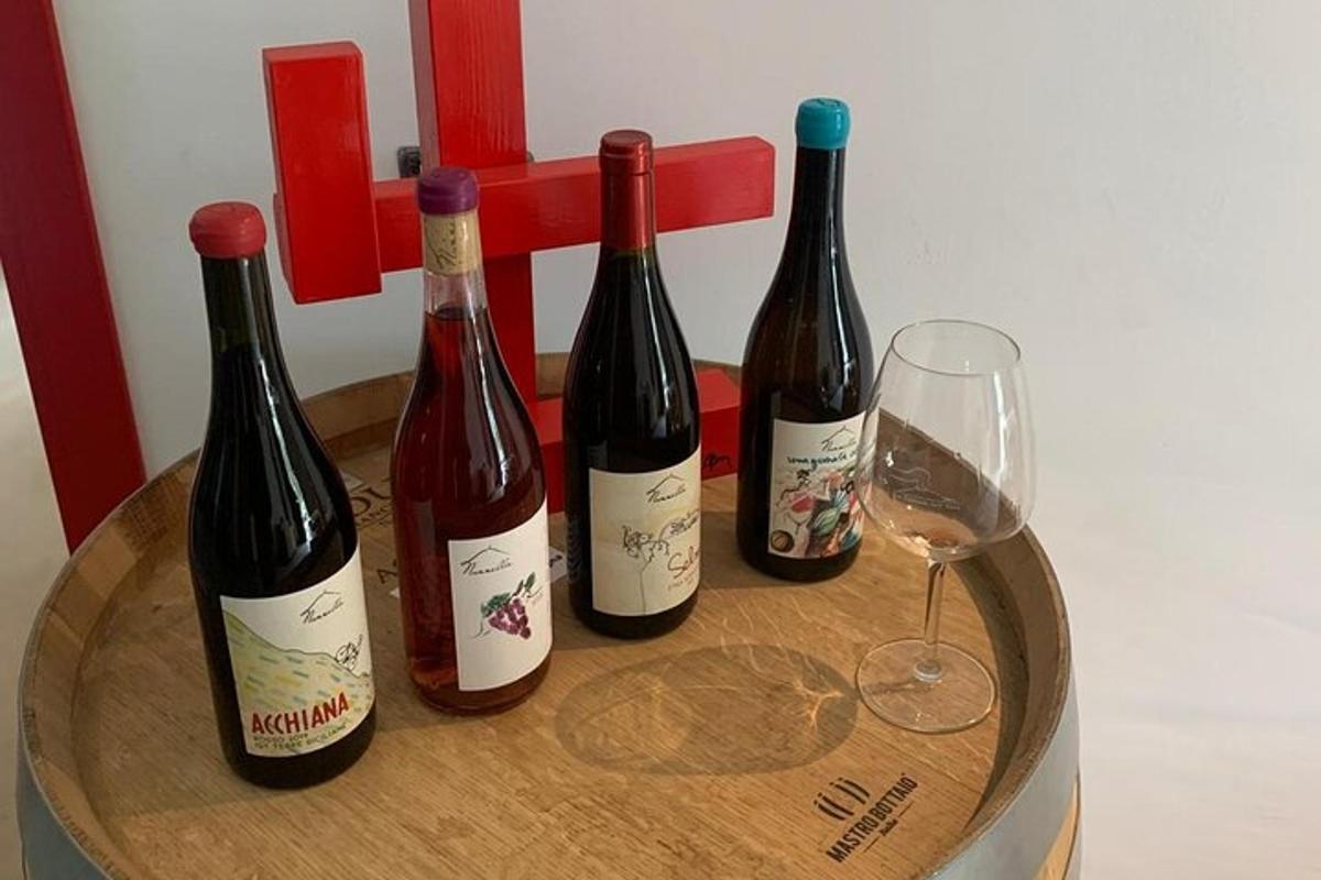 four bottles of wine on a barrel with a glass