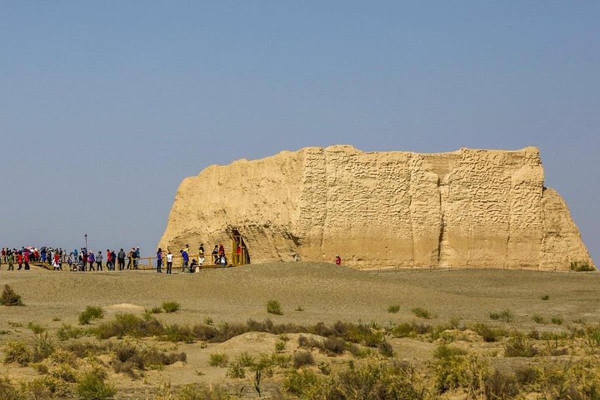 a group of people standing in front of a large rock