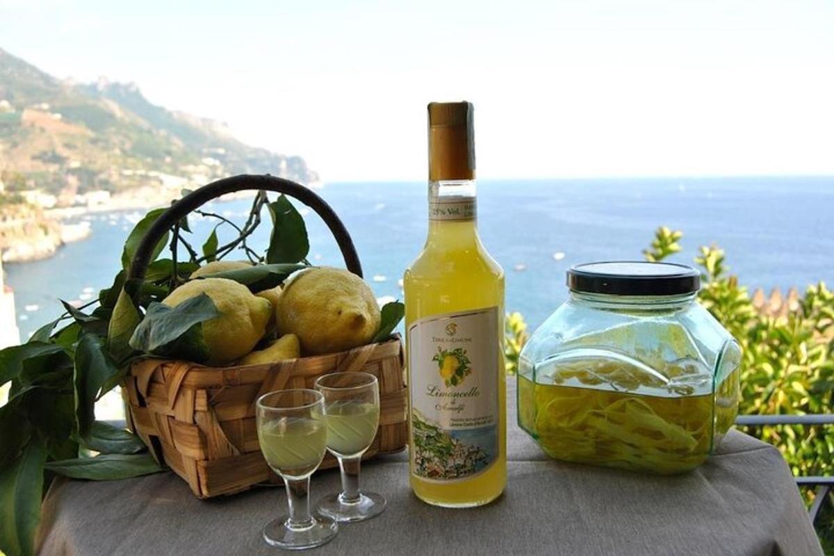 una bottiglia di vino e due bicchieri su un tavolo con un cesto di frutta