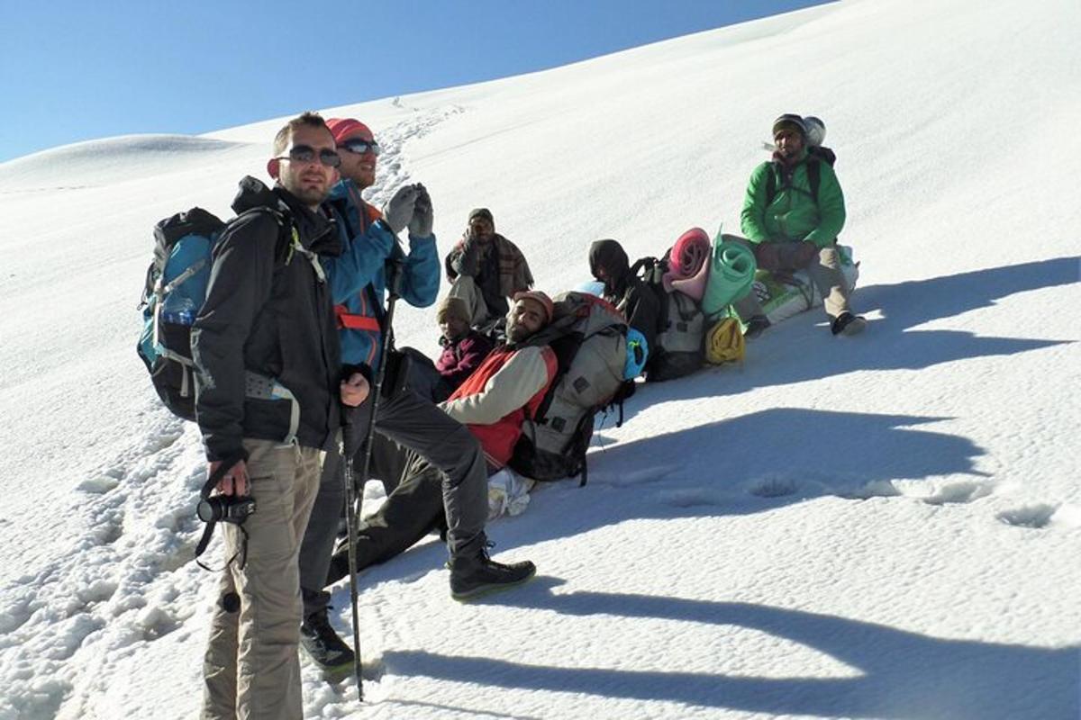 a group of people standing on a snow covered mountain
