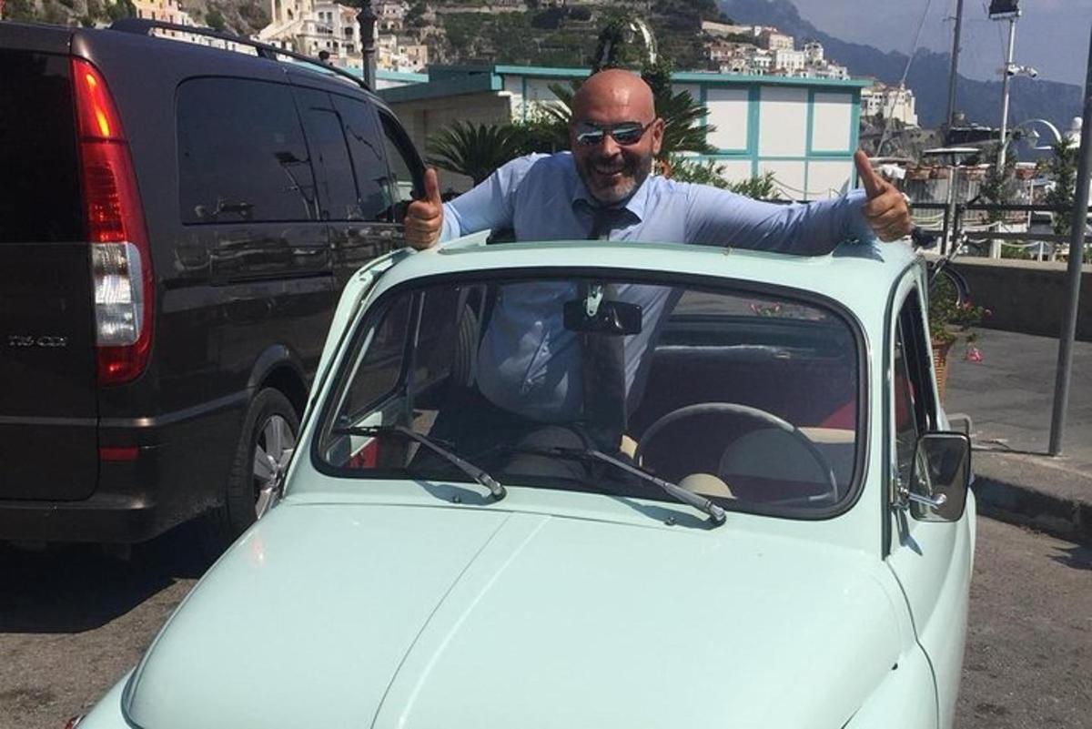 un uomo che fa il pollice in su mentre è seduto in macchina