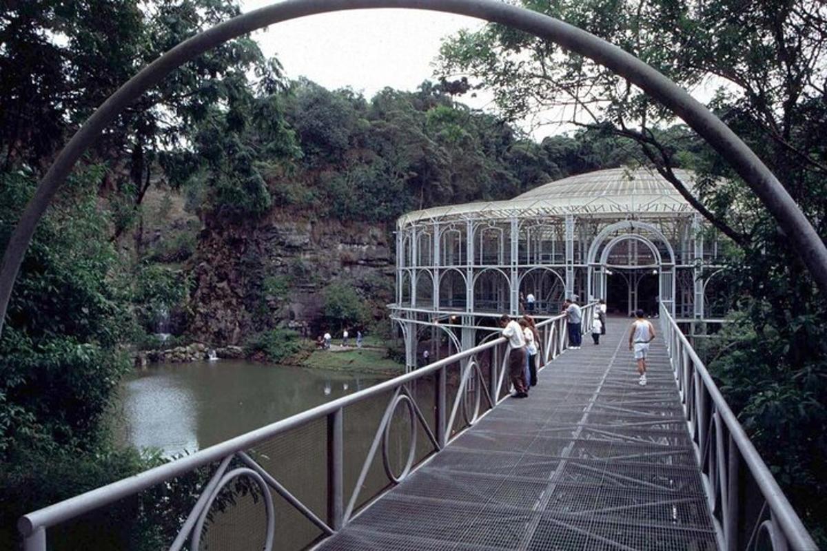 a group of people walking across a bridge over a pond