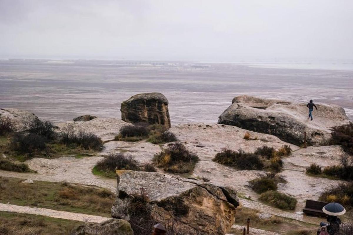 a person standing on some rocks near the ocean