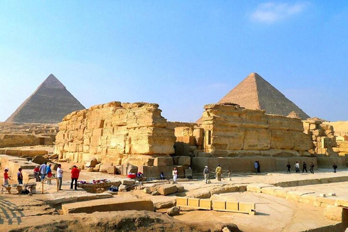 a group of people standing in front of pyramids