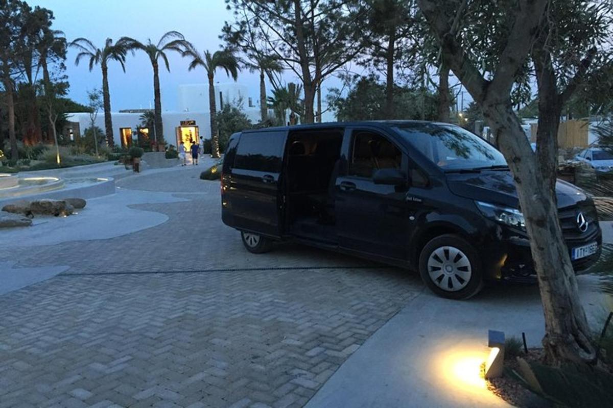 uma van preta estacionada ao lado de uma árvore