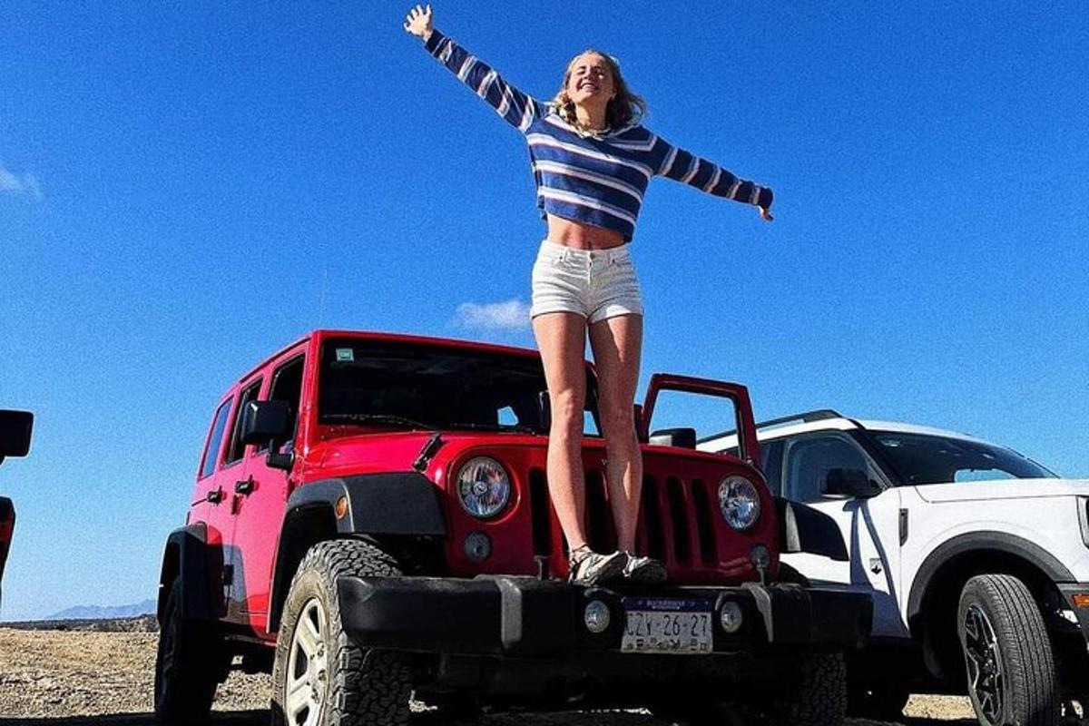 una donna in piedi sul retro di un camion rosso
