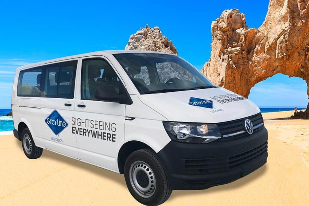 een witte bestelwagen geparkeerd op een zandstrand