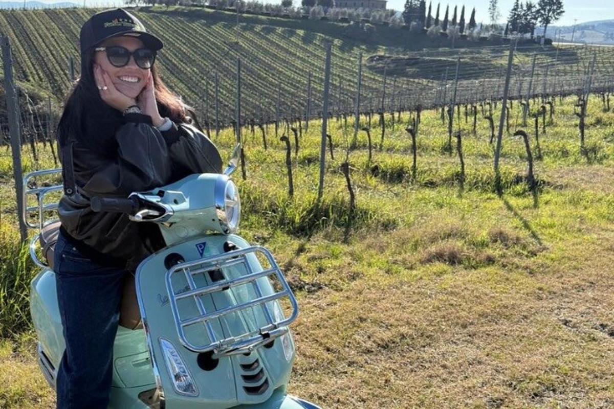 een vrouw die op een scooter zit in een wijngaard