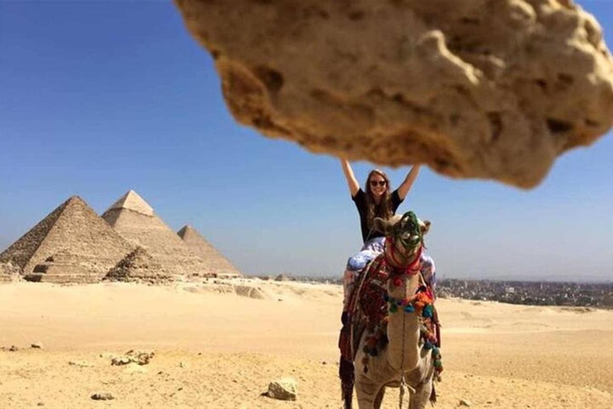 nainen ratsastaa hevosella pyramidien edessä