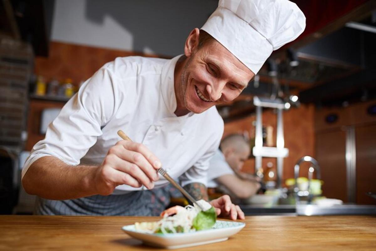 um chef preparando um prato de comida em uma cozinha