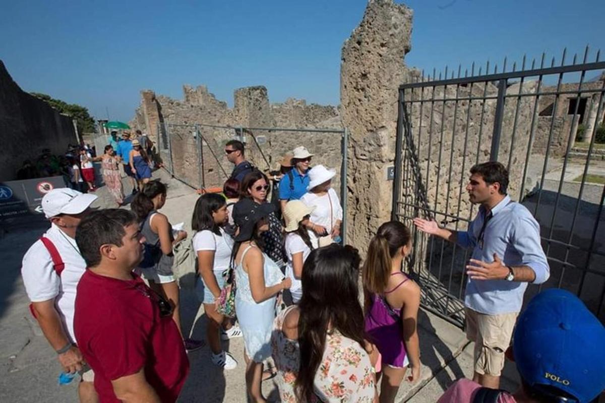 Un grupo de personas de pie cerca de una valla