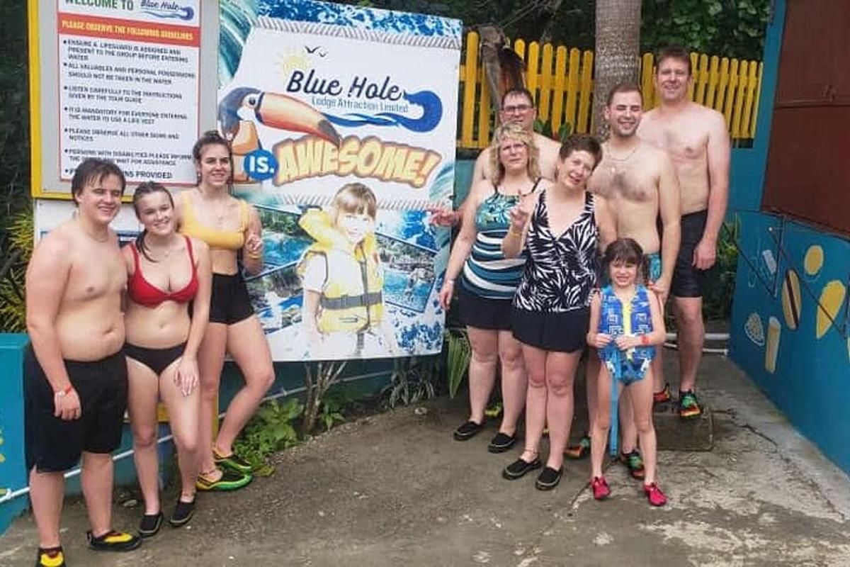 un gruppo di persone in piedi davanti a un cartello