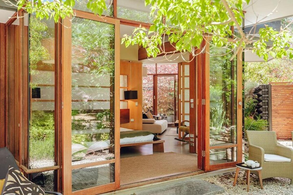 uma sala de estar com grandes portas de vidro e móveis