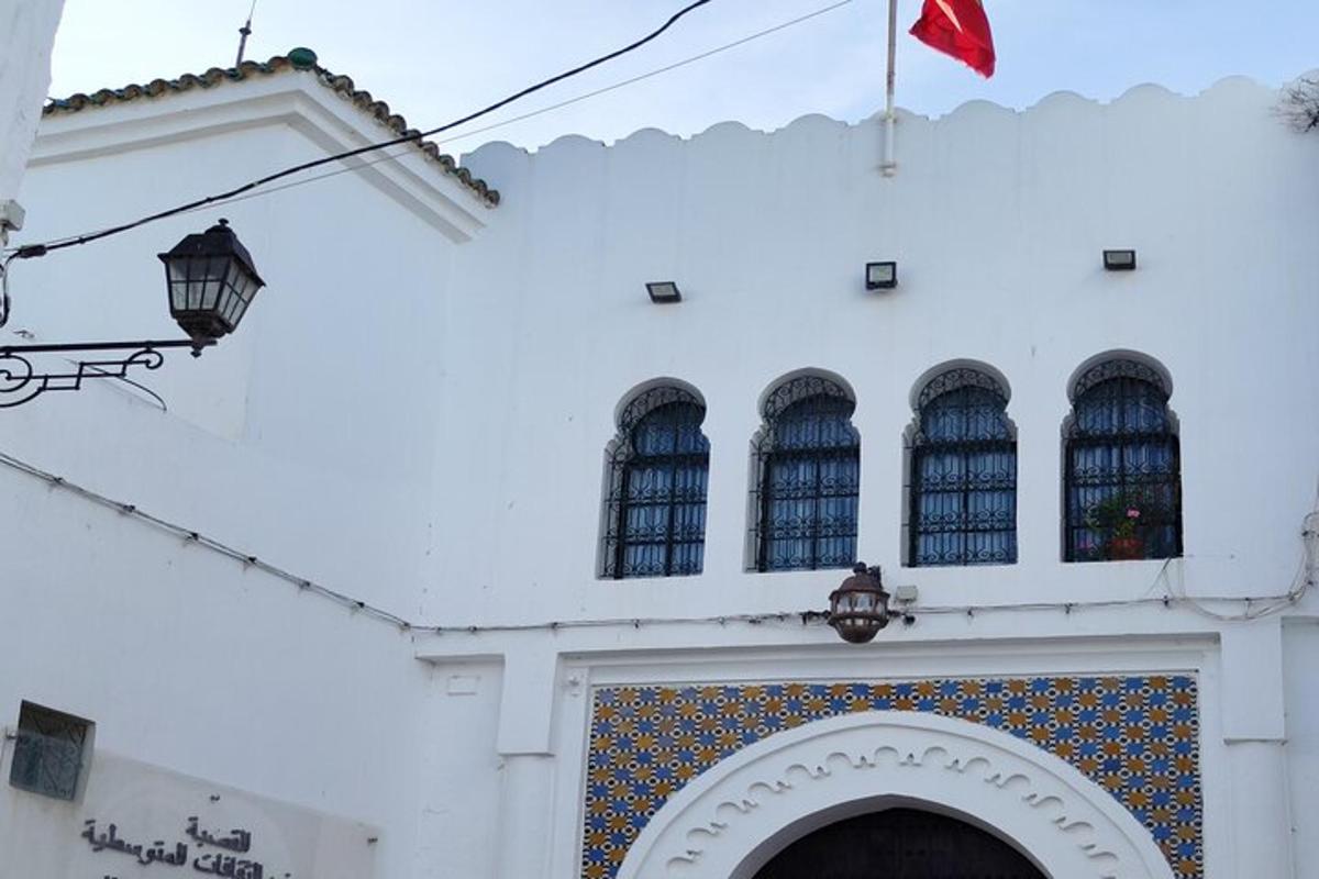 um prédio branco com uma bandeira vermelha no topo