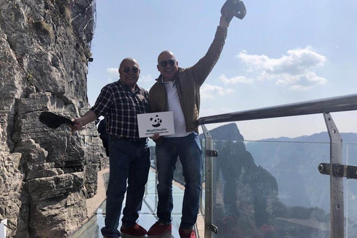 two men standing on a ledge at the edge of the grand canyon