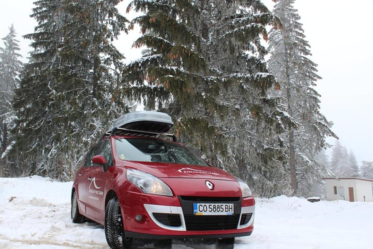 červené auto je zaparkované v snehu