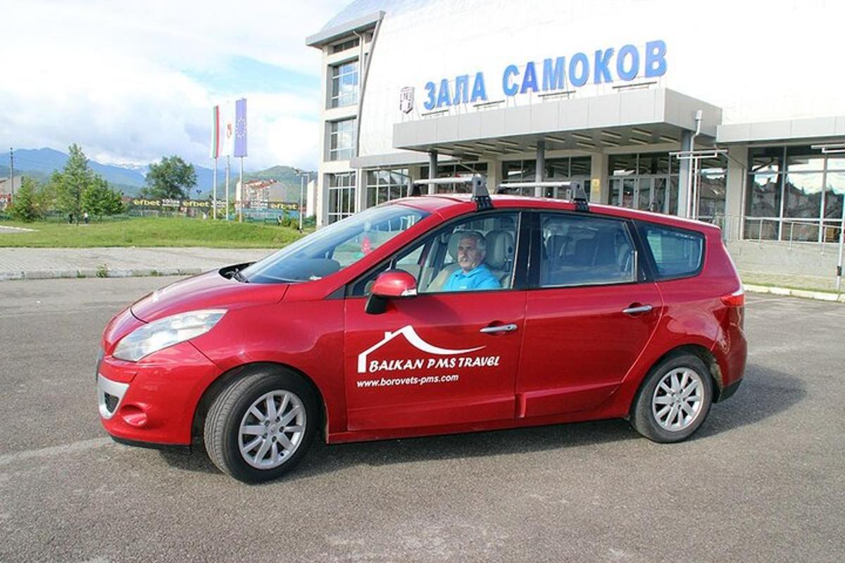 malé červené auto zaparkované pred budovou