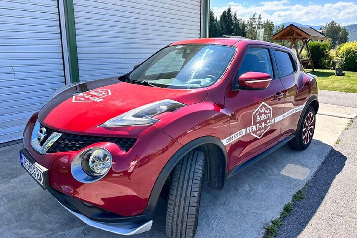 a small red car parked in a driveway