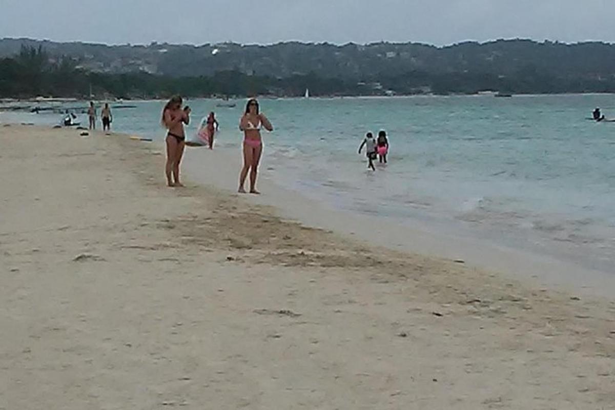 en gruppe mennesker som går på stranden