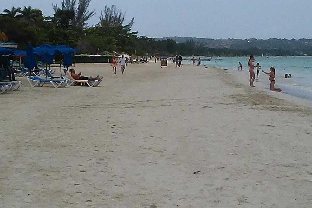 en gruppe mennesker som går på en strand