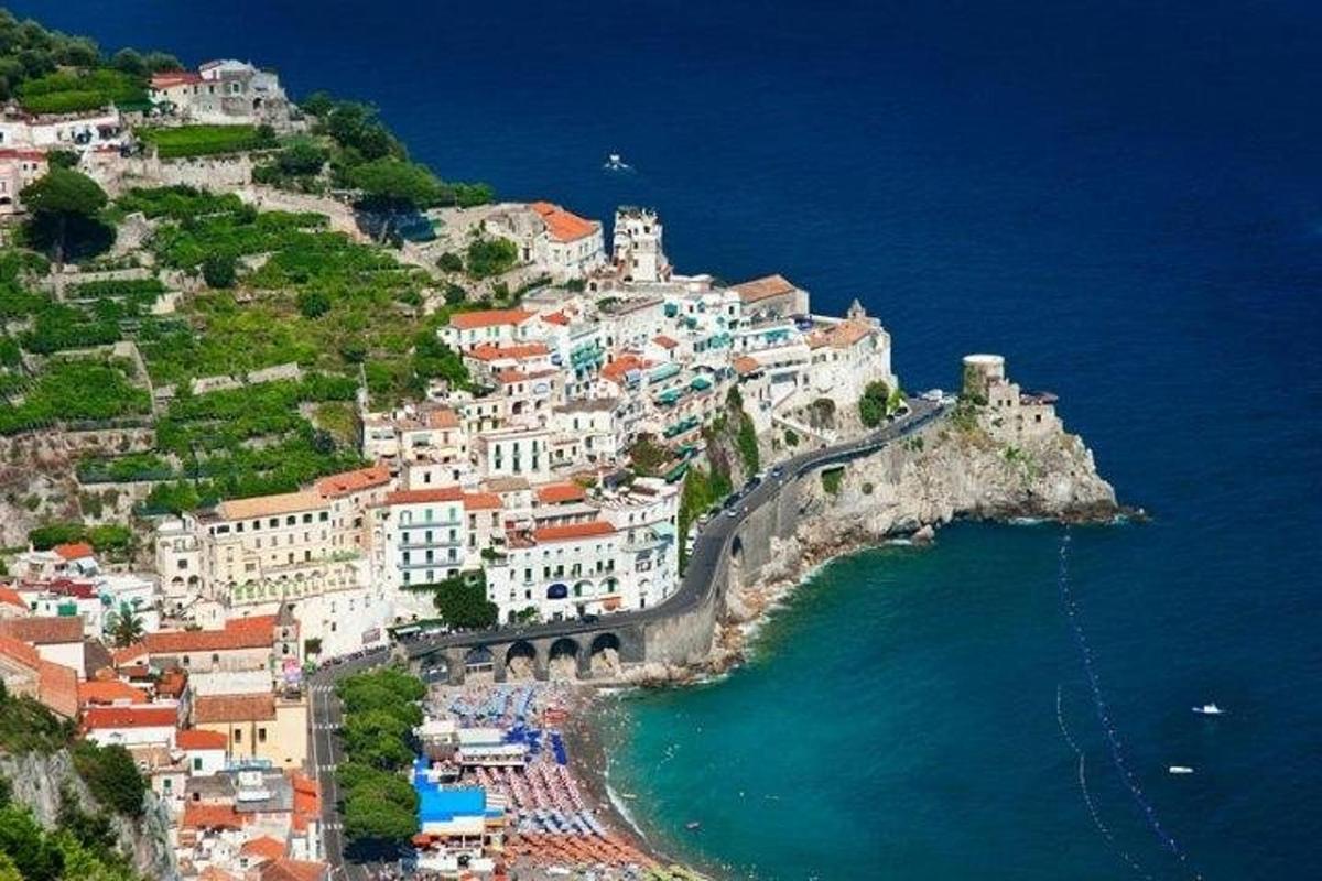 a group of buildings on a hill next to the ocean