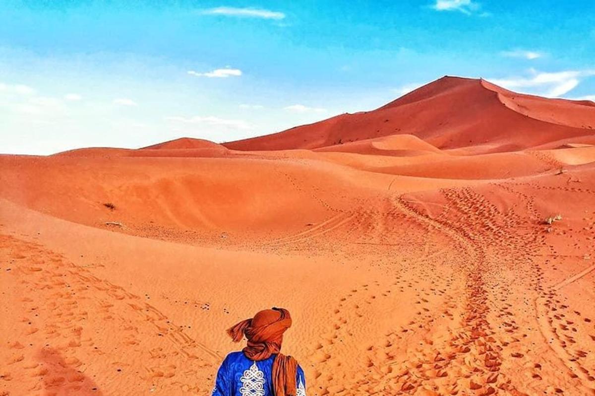 un uomo in piedi nel deserto che guarda una montagna