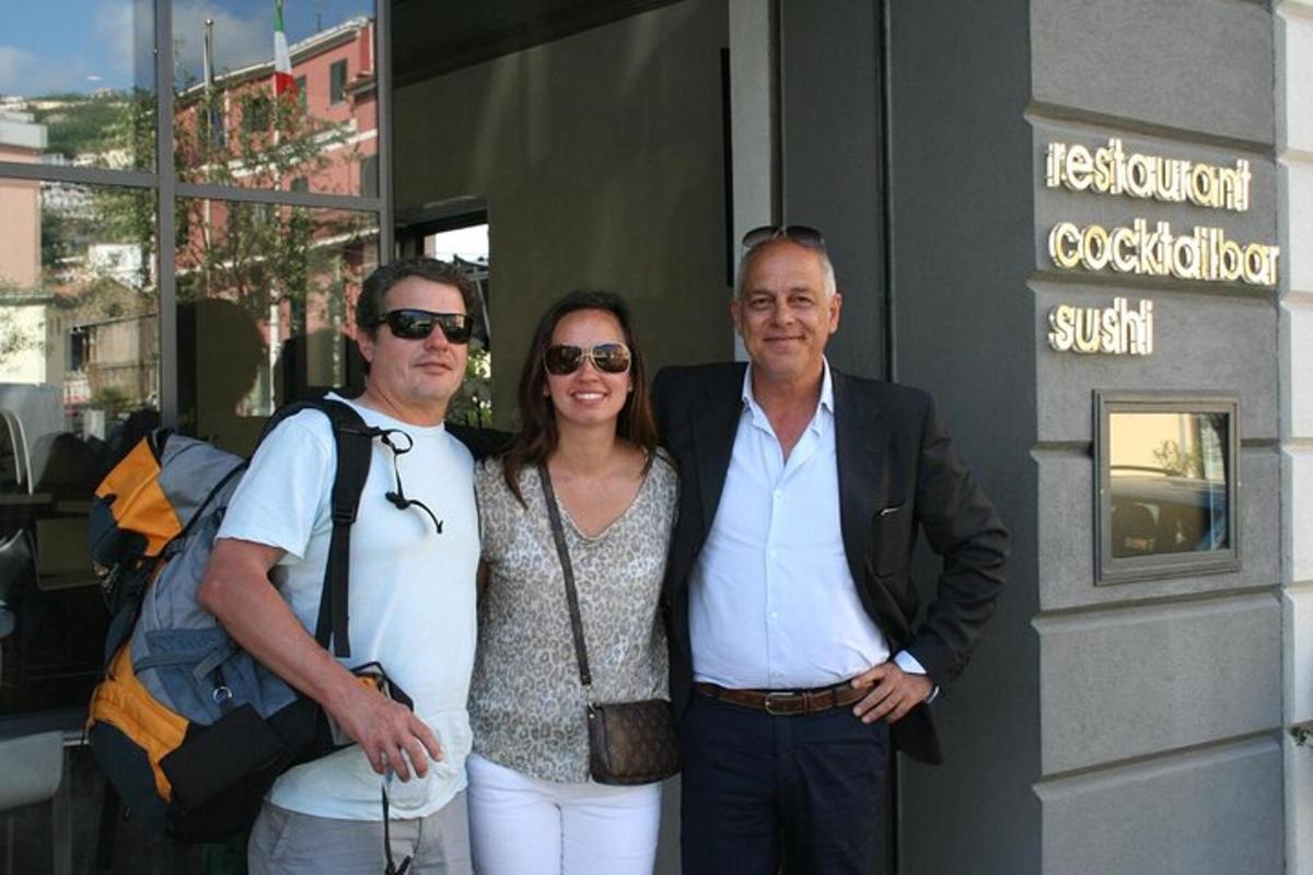 skupina treh ljudi, ki stojijo pred stavbo