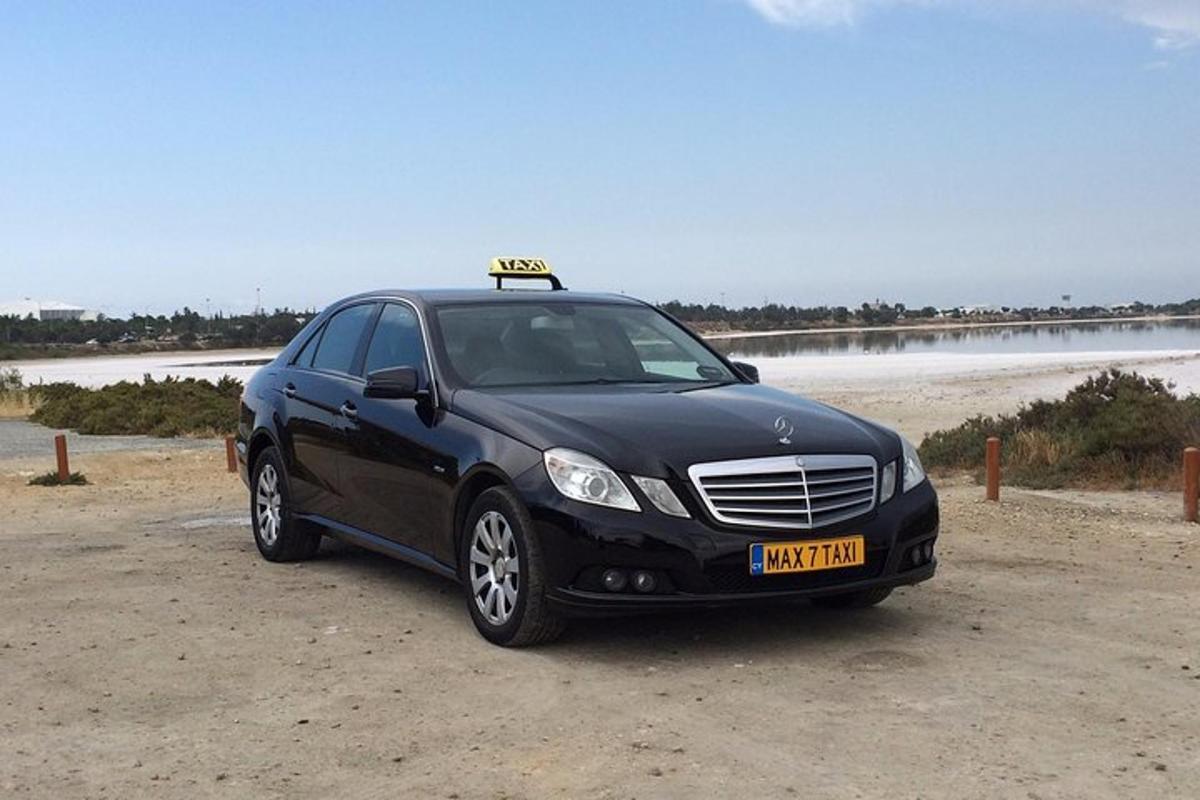 un'auto nera parcheggiata accanto a una spiaggia