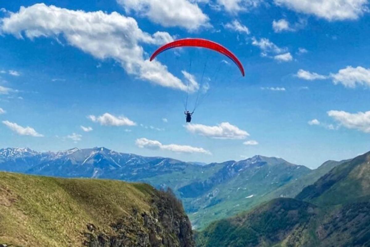 osoba letící s padákem nad horou