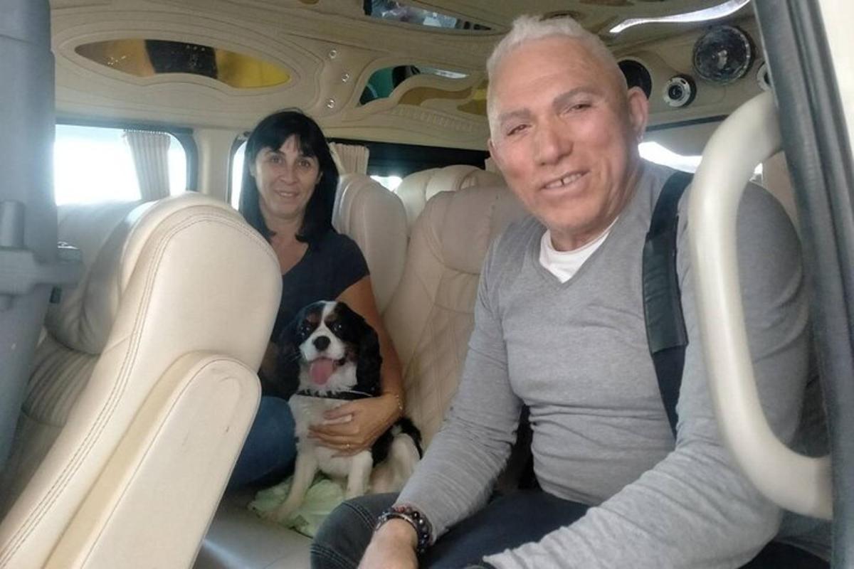 a man and a woman sitting in the back of a car with a dog