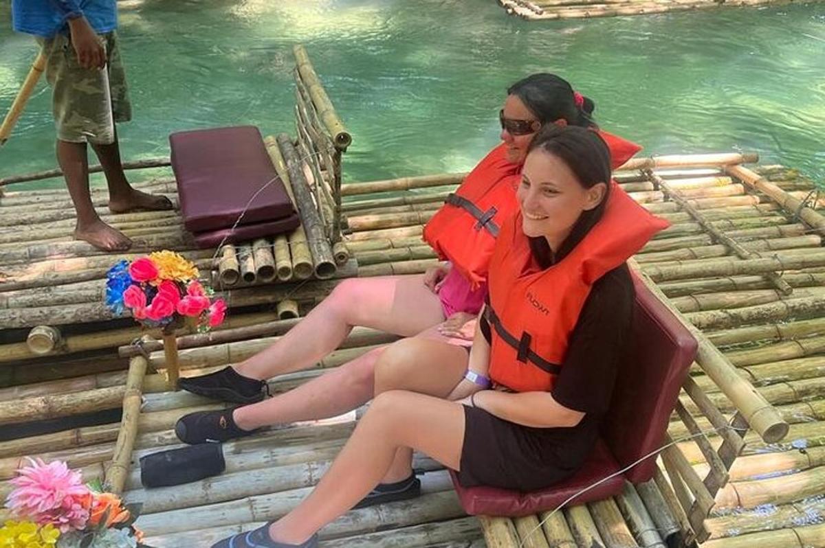 Dos mujeres y un bebé sentados en una balsa junto al agua