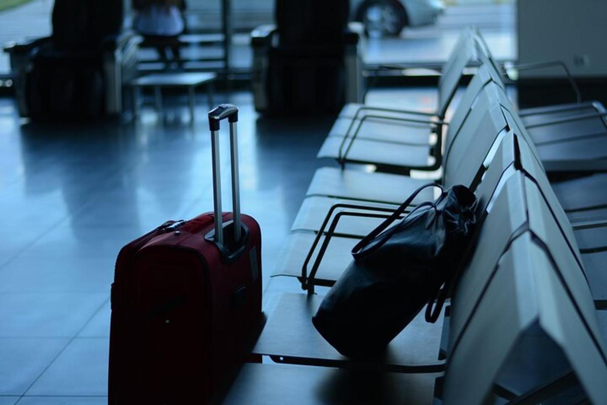 Δύο αποσκευές κάθονται σε ένα παγκάκι σε ένα αεροδρόμιο