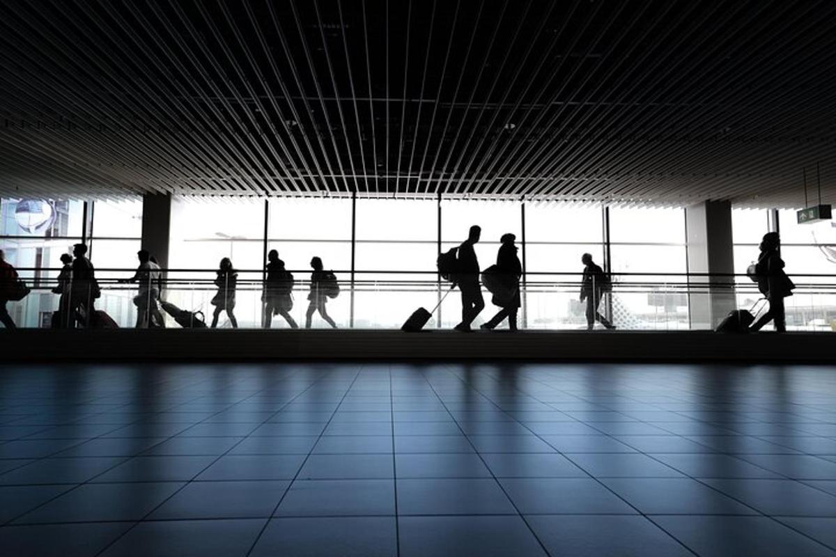 μια ομάδα ανθρώπων που περπατούν γύρω από ένα αεροδρόμιο