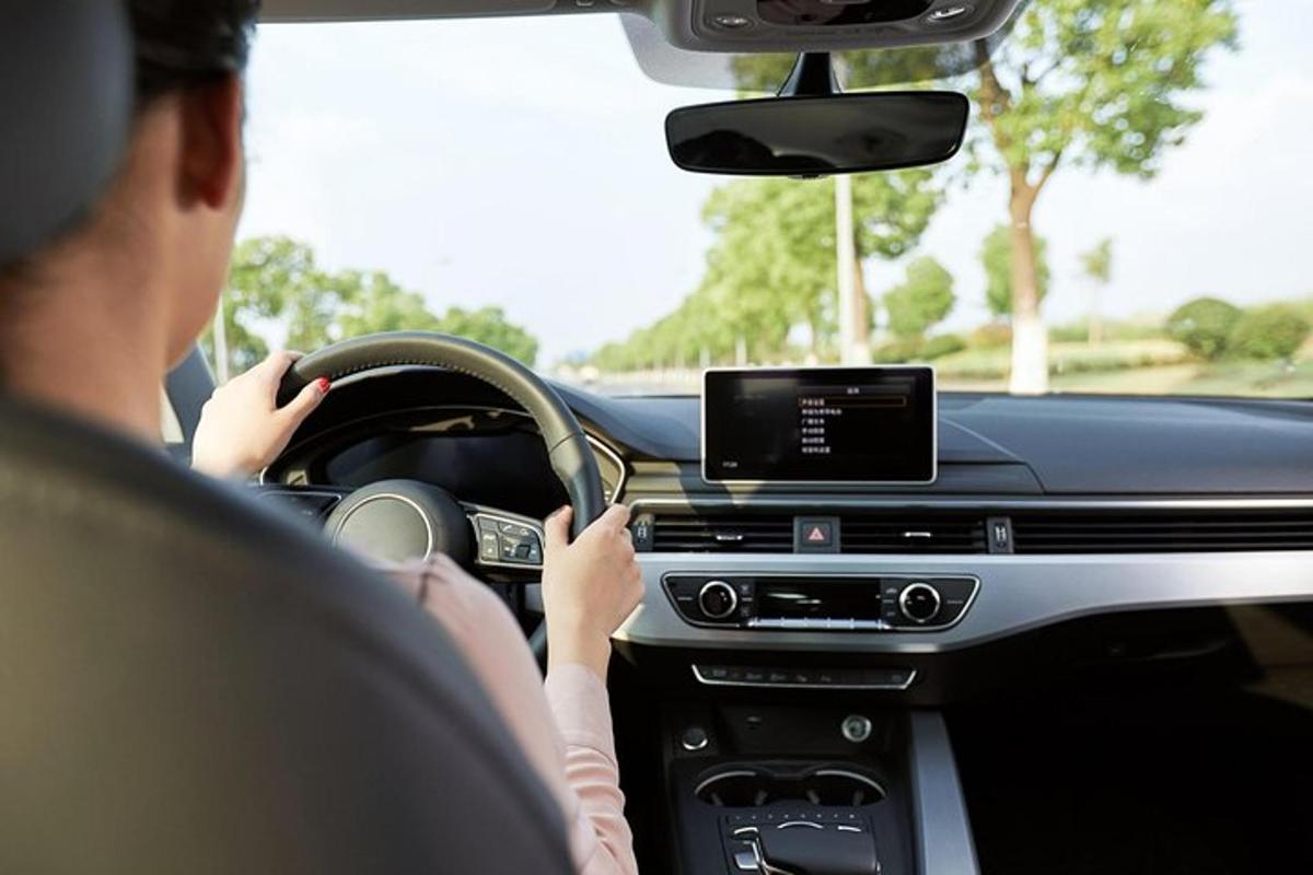 a man driving a car with a tablet