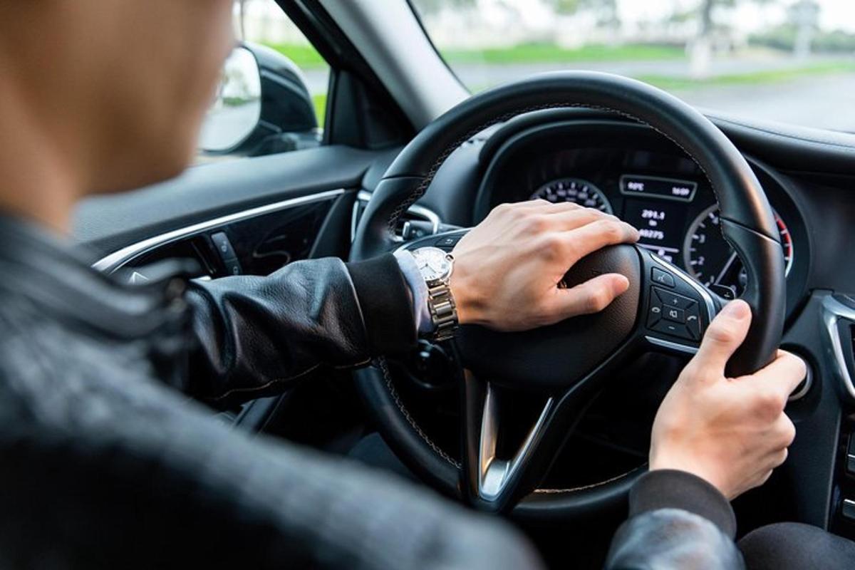 a man driving a car with his hands on the steering wheel
