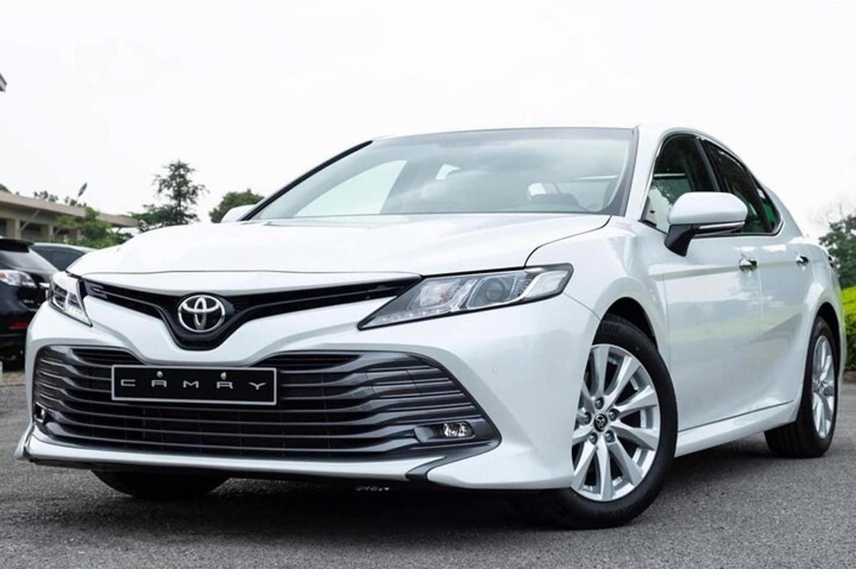 baltas „Toyota Camry“ automobilis, pastatytas automobilių stovėjimo aikštelėje