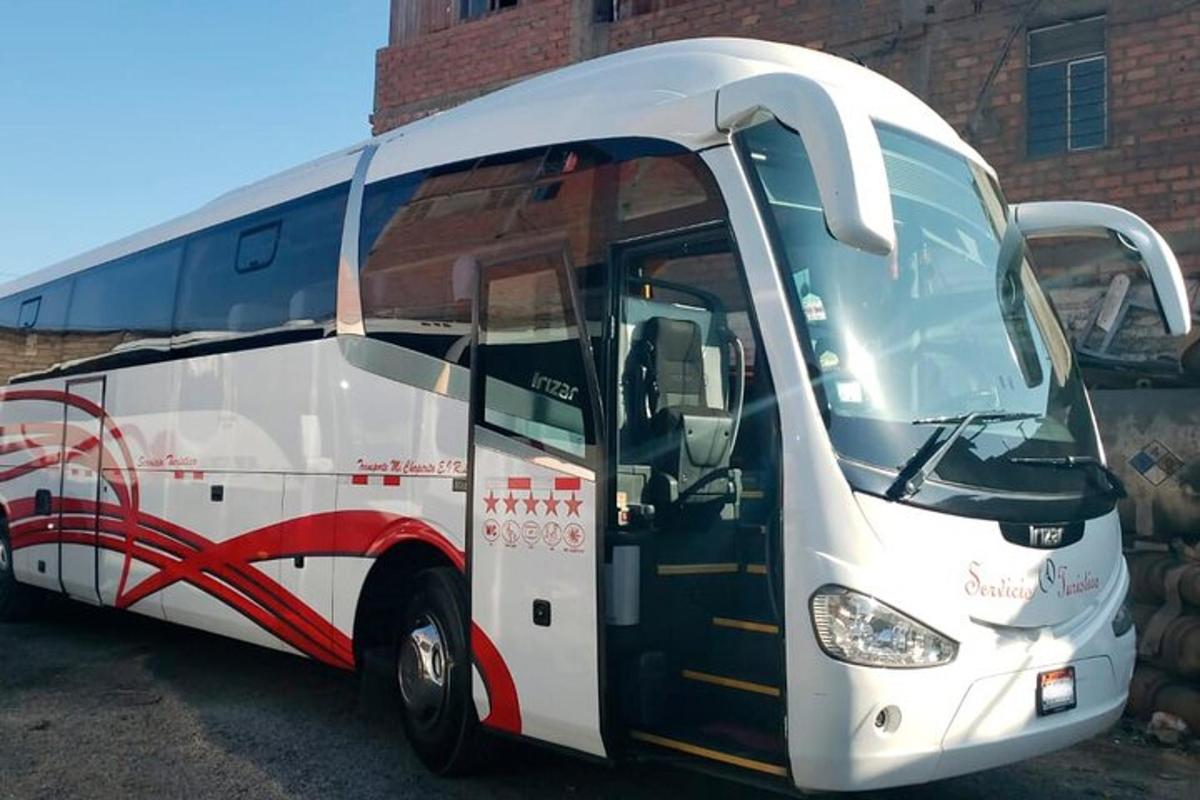 valge buss pargitud telliskivimaja ette