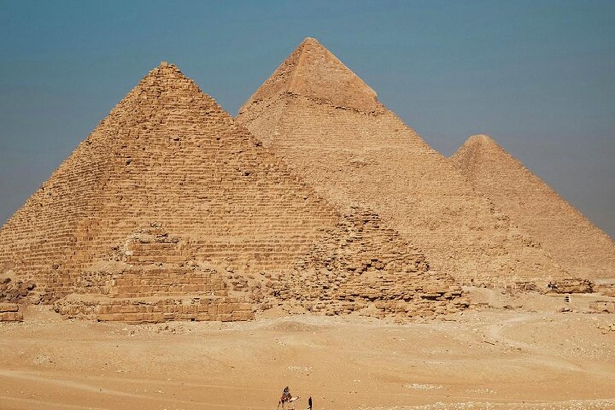Skupina pyramid v poušti pod modrou oblohou