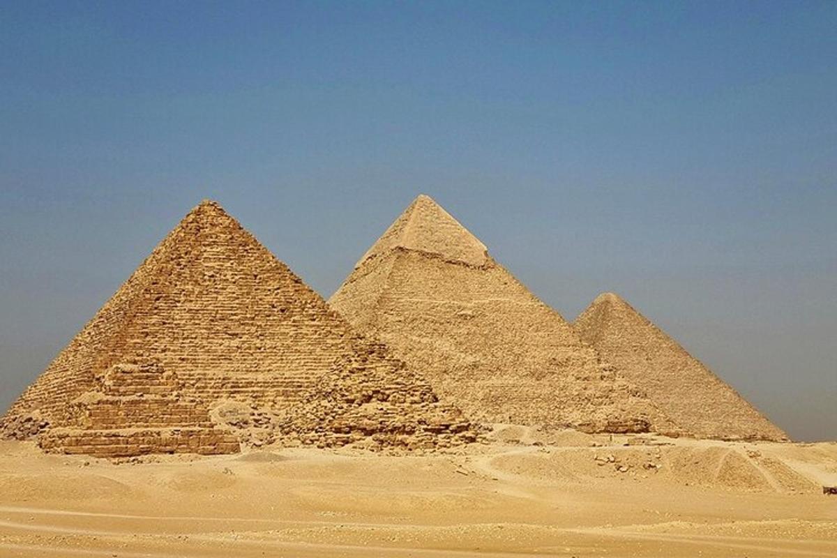 un gruppo di piramidi nel deserto sotto un cielo azzurro