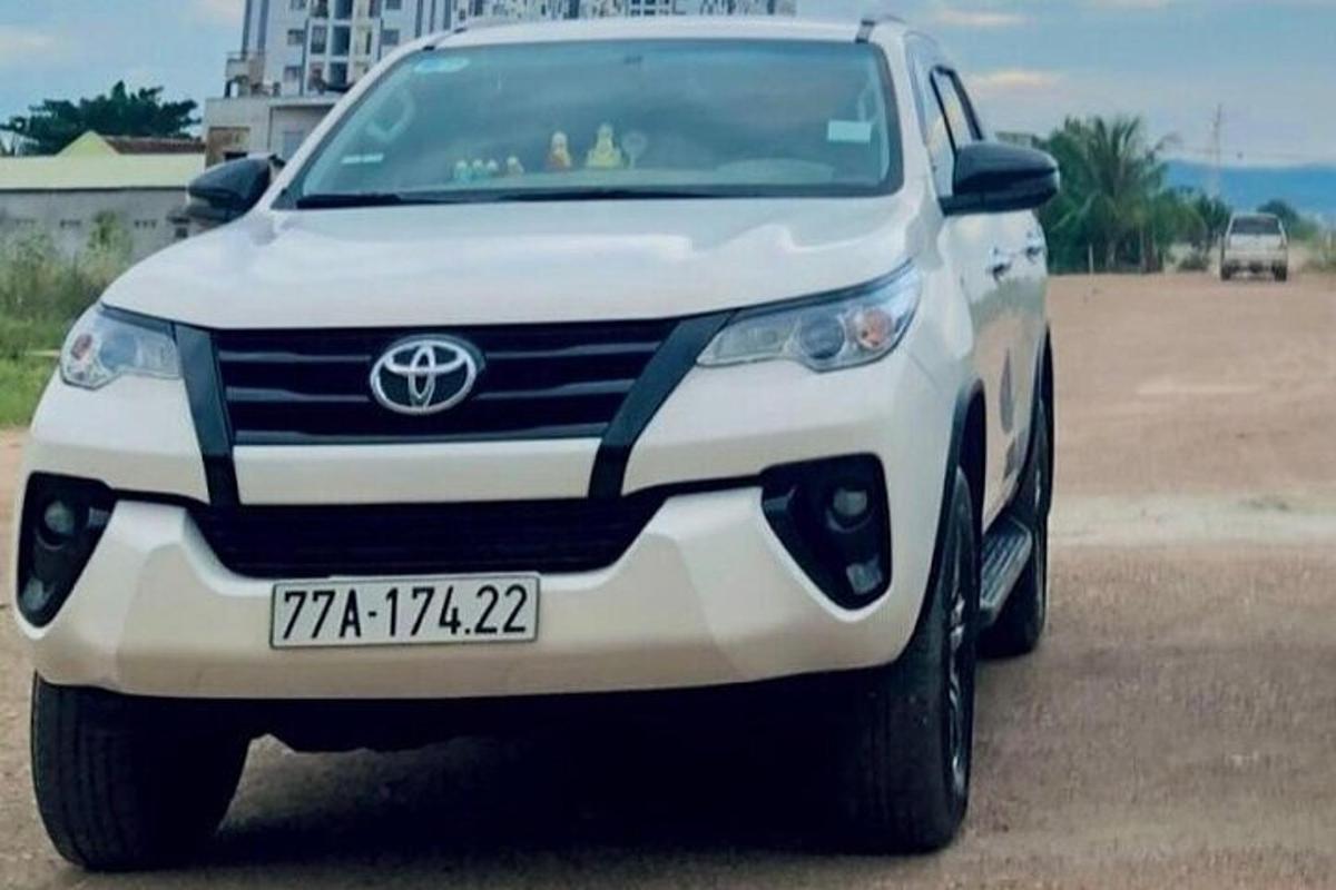 bílé auto zaparkované na kraji silnice