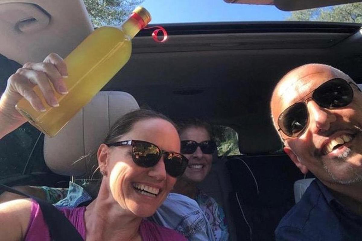 um grupo de pessoas sentadas em um carro com uma bebida